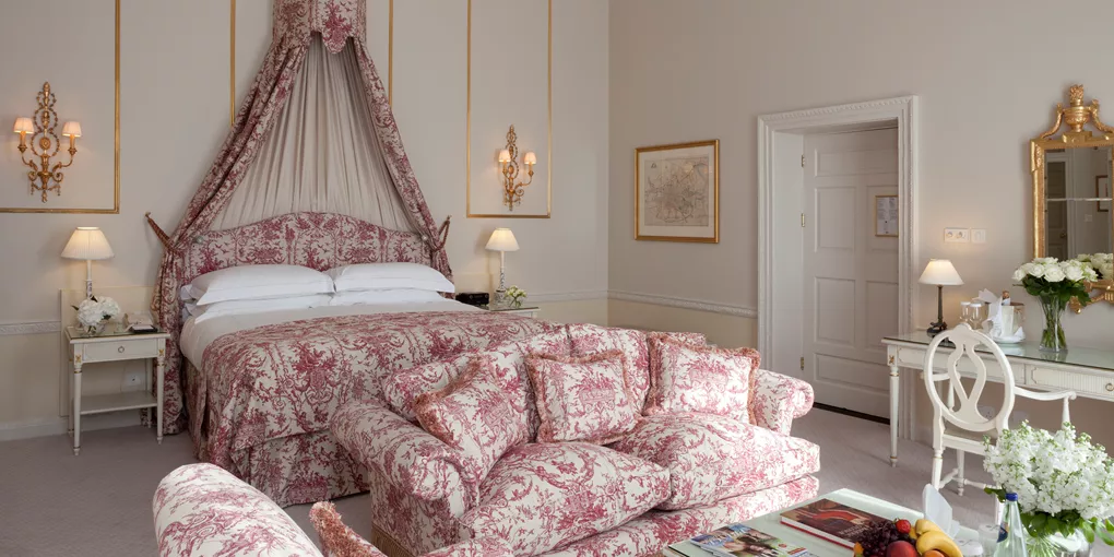 Junior suite with large bed and pink couch in the Merrion Hotel in Dublin