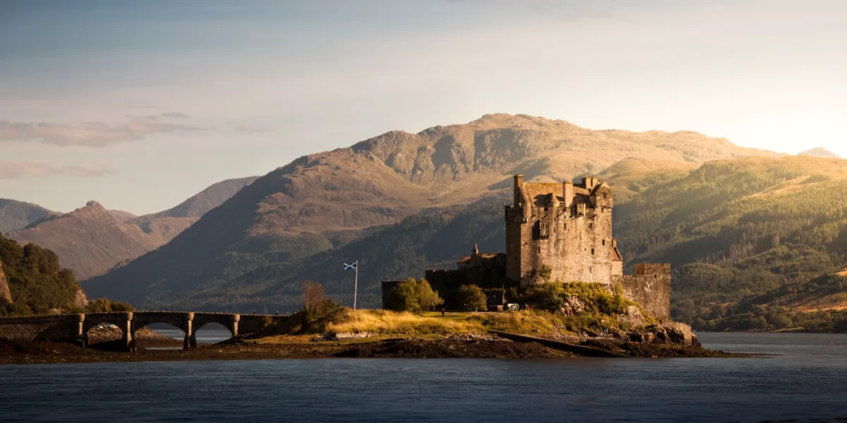 An Eilean Donan Castle on an island with mountains in the background